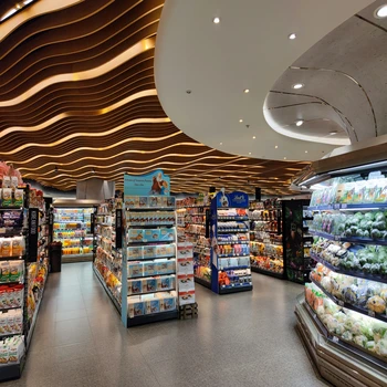 Allée centrale d'un hypermarché avec une grande hauteur sous plafond.